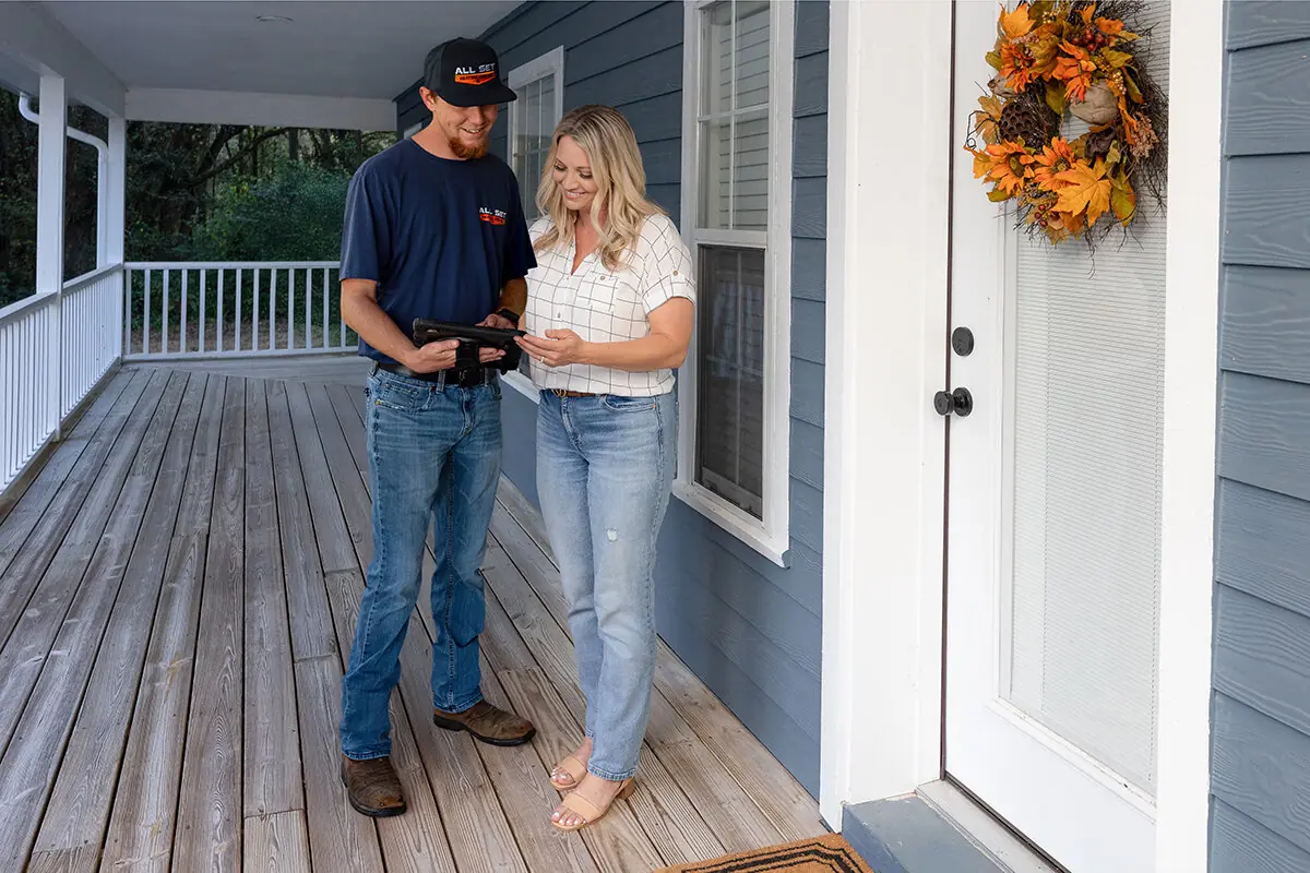 An All Set technician walking a homeowner through what he found, at her front door